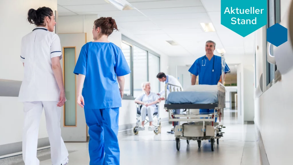 Drei Pflegekräfte laufen über einen Krankenhausflur