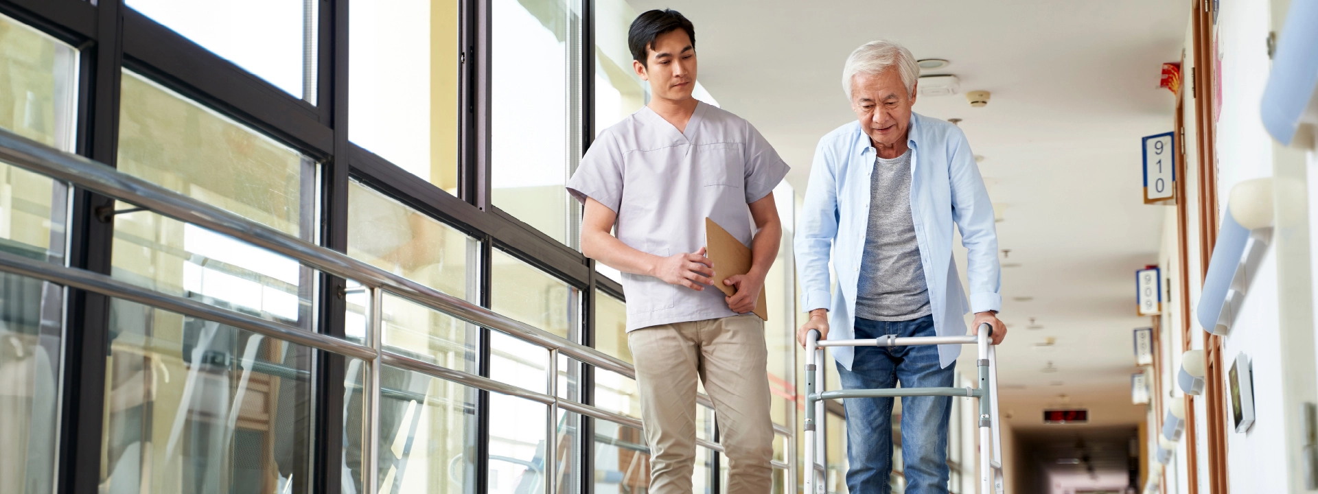 Pflegesatzverhandlungen in Reha-Einrichtungen Ein Pfleger hilft einem Patienten in einer Rehaklinik beim Laufen.